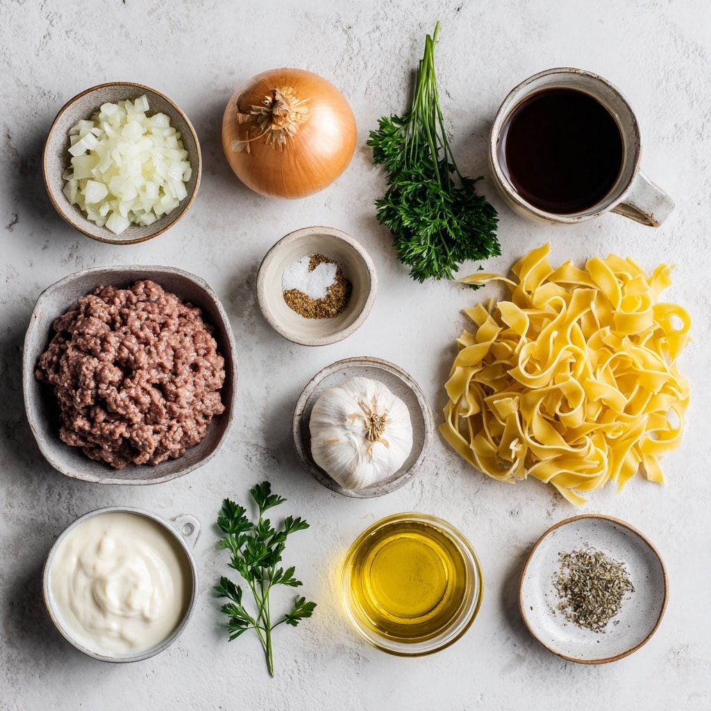 This image shows a white plate filled with soft, wide egg noodles that are lightly curled and coated in a creamy light brown sauce. Mixed throughout the noodles are small, finely crumbled pieces of cooked ground meat, also coated in the sauce with a slightly glossy texture. Tiny specks of green herbs are scattered within the sauce, adding a subtle color contrast. The noodles and meat sauce are evenly mixed and appear tender and rich, filling the plate close to the edges. The background is a white marbled surface, giving a clean and simple look to the presentation. photo taken with an iphone --ar 4:5 --v 7